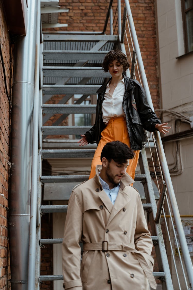 A Man And A Woman Walking Down On Steel Stairs