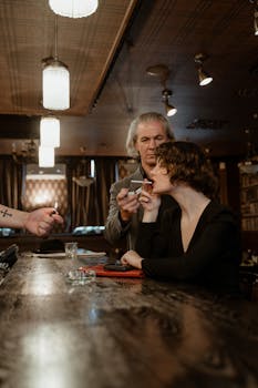 A man and woman share a cigarette in a vintage-style bar, creating a moody ambiance.