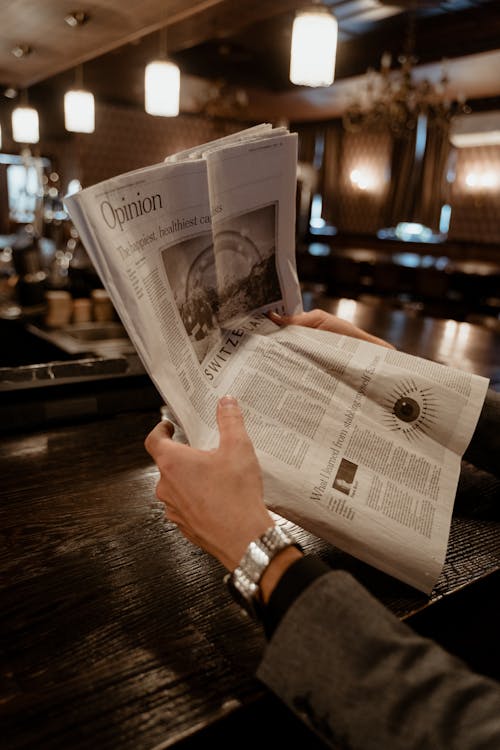 Close-Up Shot of a Person Holding Newspaper