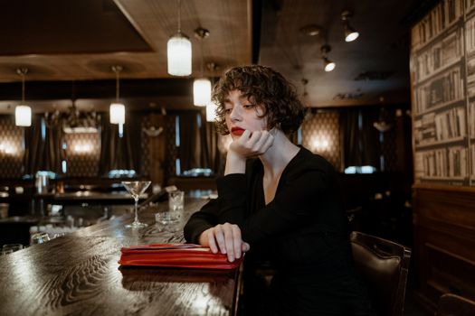 Serious Woman Leaning on Bar Counter
