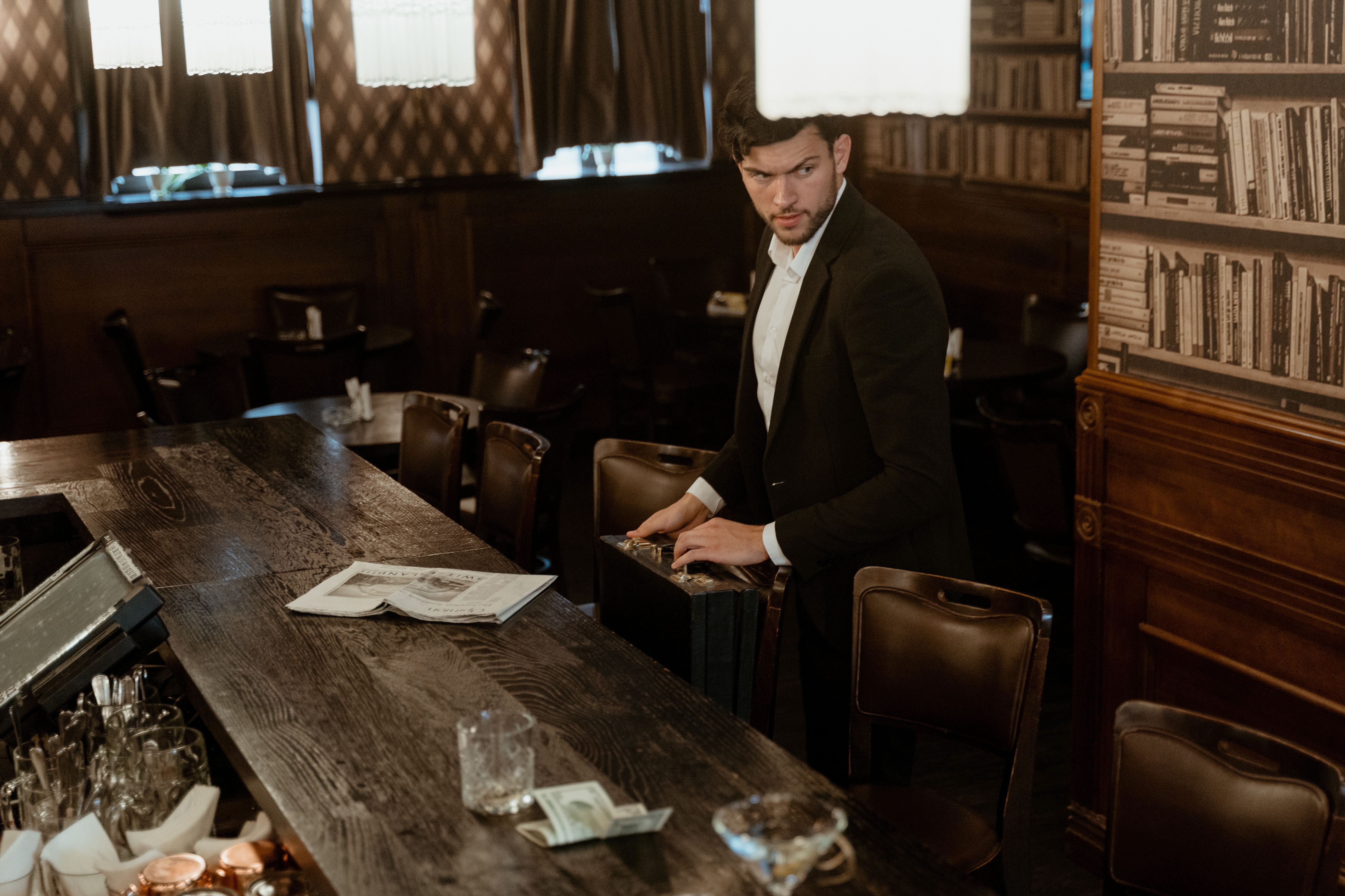 A Man in Black Suit Standing Near the Bar Counter · Free Stock Photo