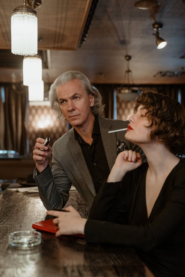 A Mature Man Beside A Woman With Cigarette 