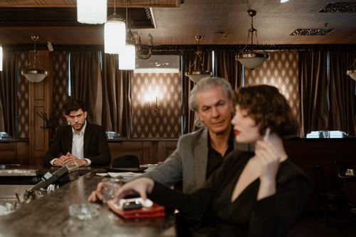 Free Three stylish adults in a classic bar setting, exuding vintage charm and elegance. Stock Photo