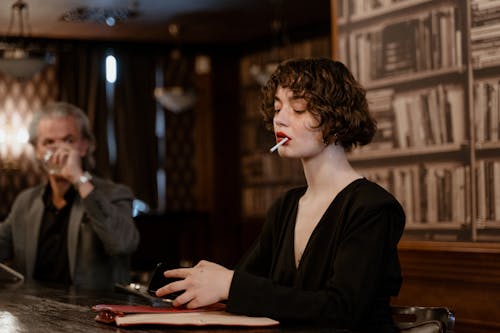 Free A Woman in Black Long Sleeve Shirt Smoking Cigarette Stock Photo