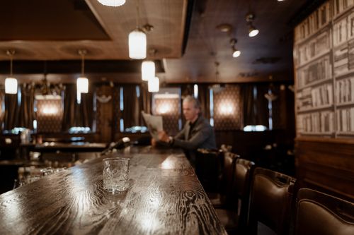 Free Warm, inviting wooden bar with vintage decor and an empty glass on the counter. Stock Photo