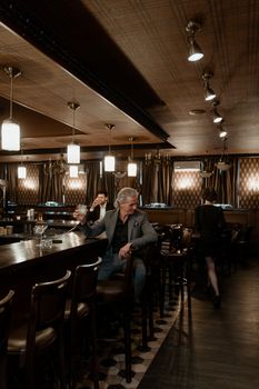 Sophisticated evening ambiance in a modern bar, featuring patrons enjoying drinks.