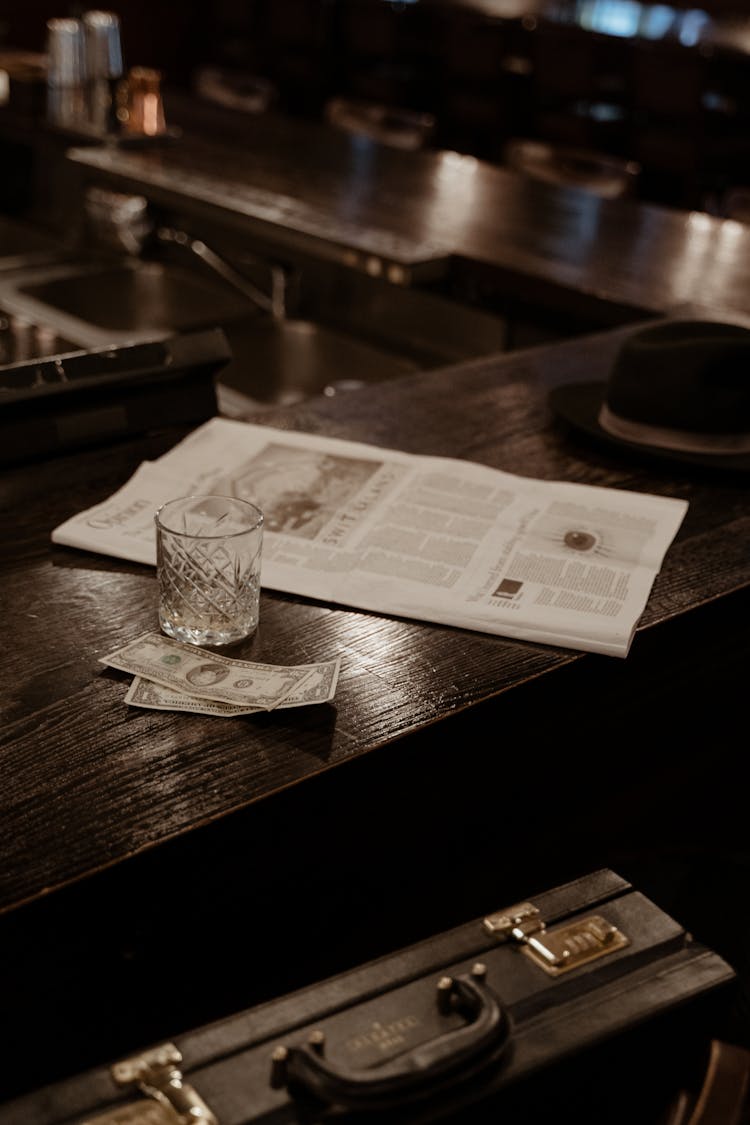 Black Hat And Newspaper On Wooden Counter 