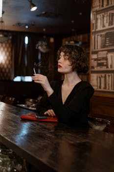 Elegant woman smoking in a dimly lit bar setting, exuding a cinematic vibe.