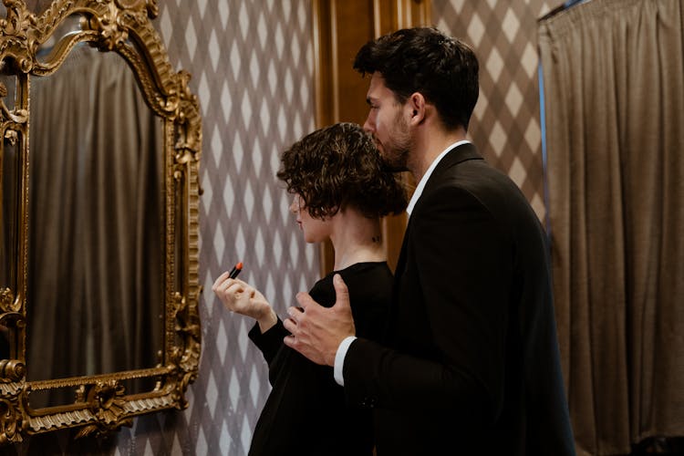 Man And Woman Looking At The Mirror