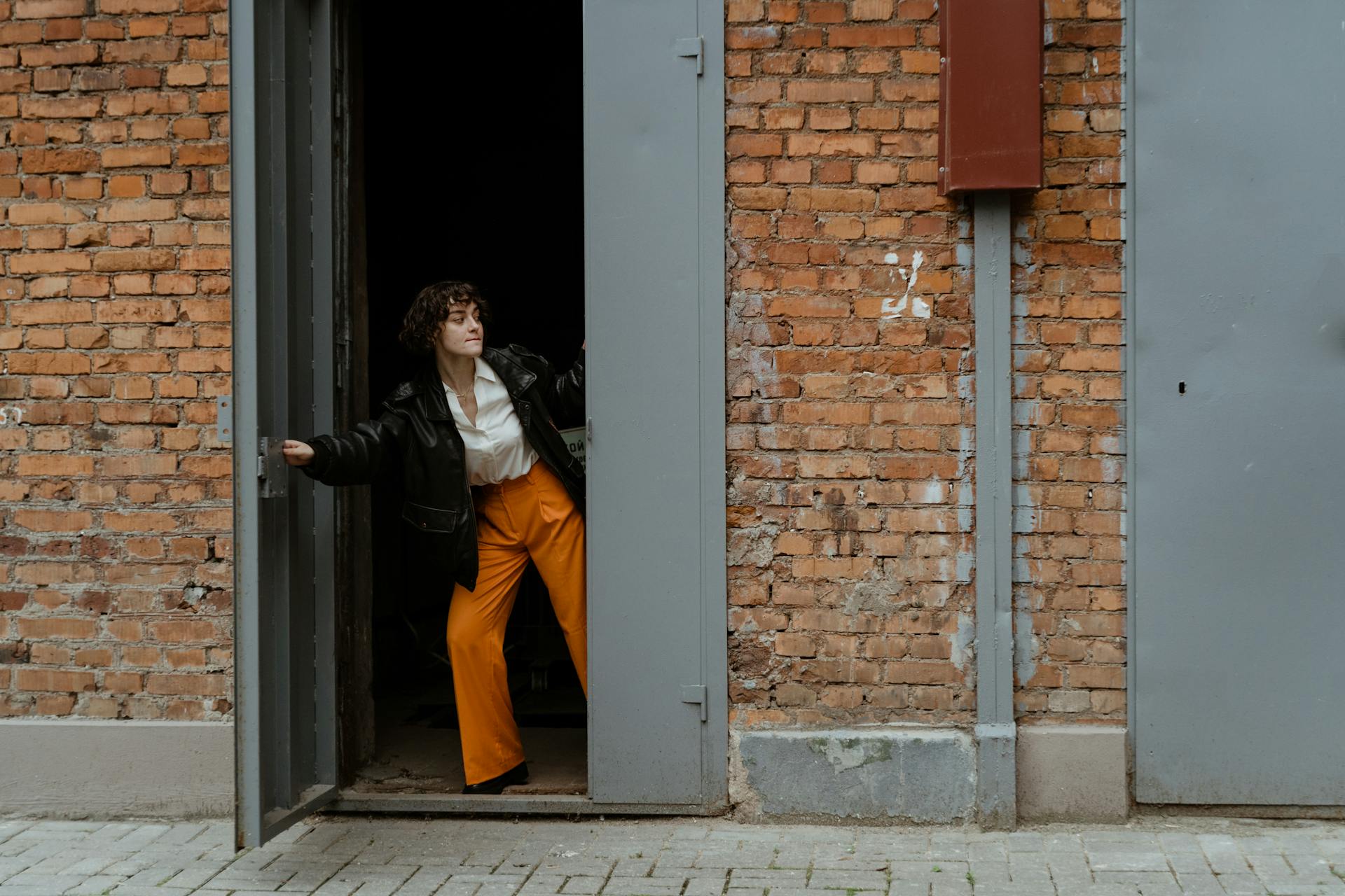 Photo of a Woman Closing a Gray Door