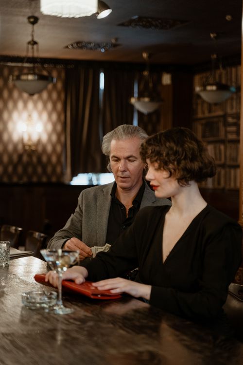 Free Sophisticated couple enjoying a stylish evening in a cozy bar atmosphere. Stock Photo