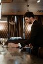 A Man in Black Suit Jacket Putting Down the Briefcase on the Chair