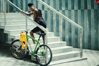 年轻女子在城市楼梯上骑自行车摆姿势，展现现代时尚