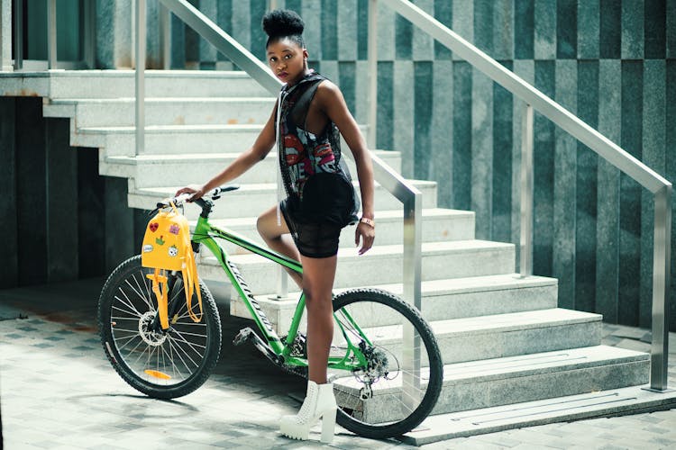 Woman Wearing Black Dress Riding Bicycle Near Stairs