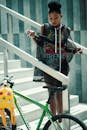 一位穿着时尚的年轻女子骑着自行车走在现代楼梯上