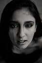 一张年轻女子的特写黑白肖像，面部表情引人注目