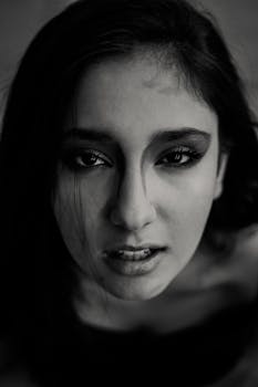 一张年轻女子的特写黑白肖像，面部表情引人注目