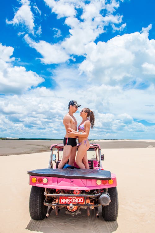 Free Man and Woman Looking at Each Other While Standing on a Buggy Stock Photo