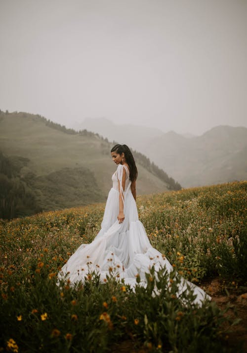 Free Woman in White Long Dress Standing on Flower Field Stock Photo