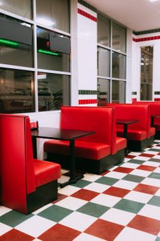 Red diner booths with checkered flooring in a retro-style interior.