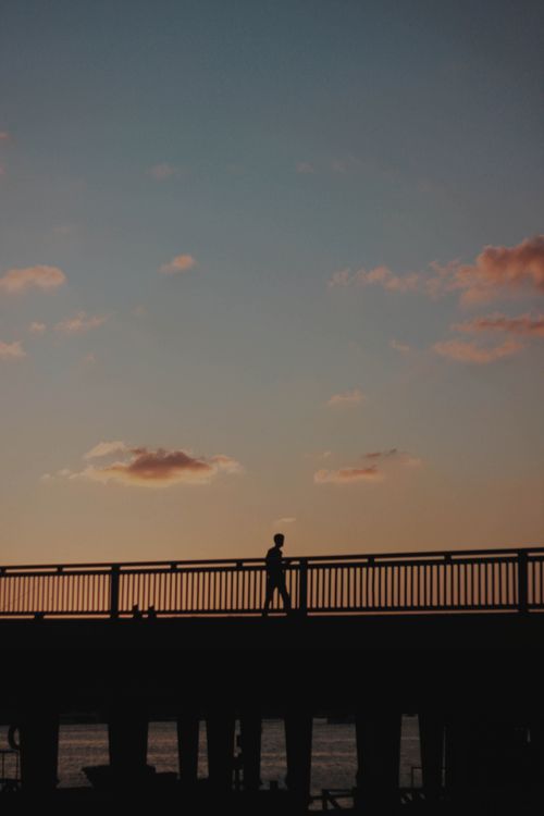 Free Silhouette of a man walking on a bridge during a serene twilight in Istanbul, Turkey. Stock Photo