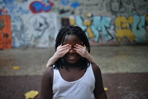 A Woman in White Tank Top Covering Her Eyes