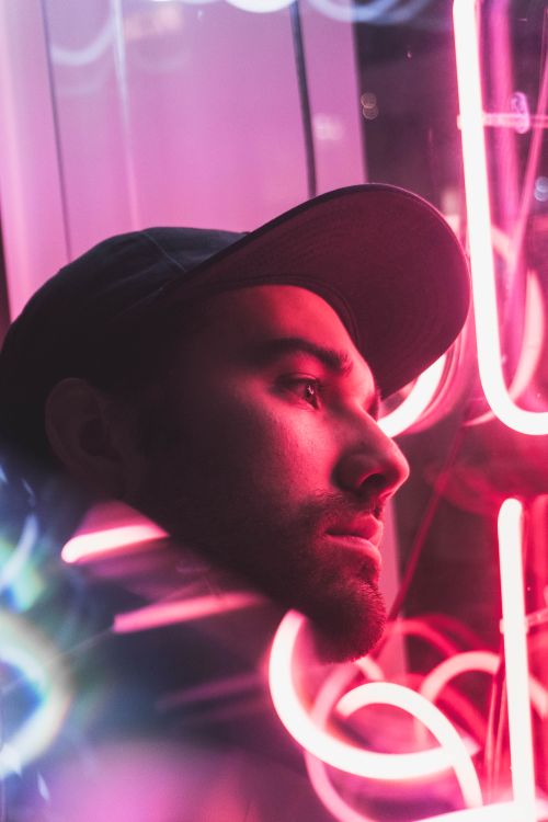 Free Close-up of a man with a beard reflecting on neon lights in Portland, Oregon. Stock Photo