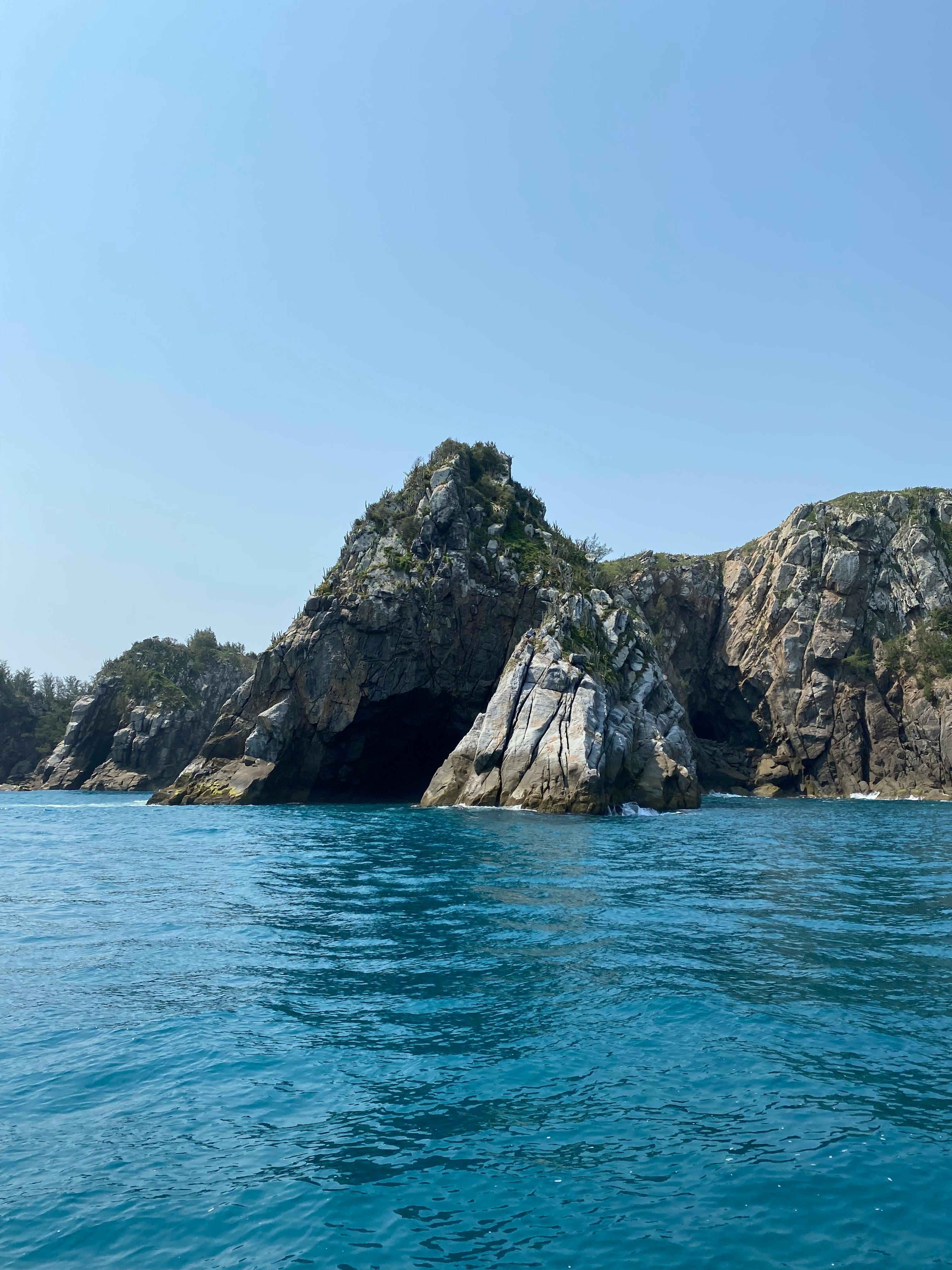 Explore the stunning rock formations along the Arraial do Cabo coastline in Brazil.