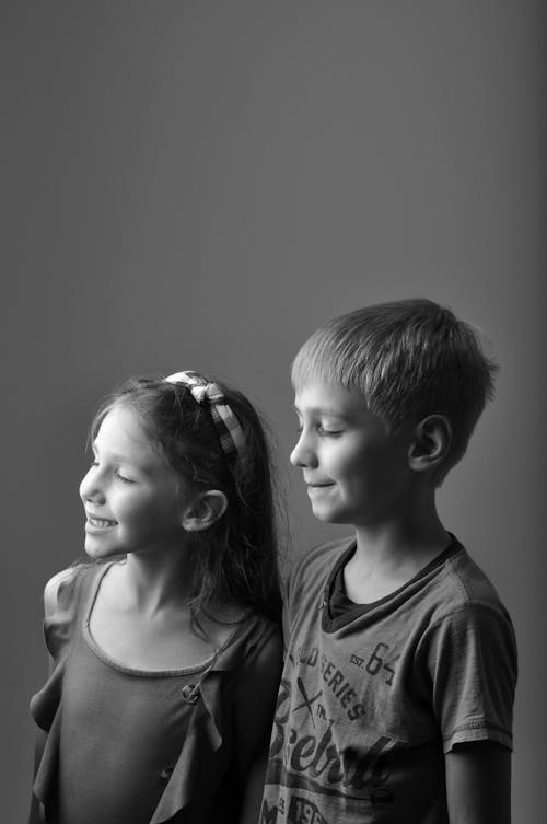 Free A Grayscale Photo of Children Smiling with Their Eyes Closed Stock Photo