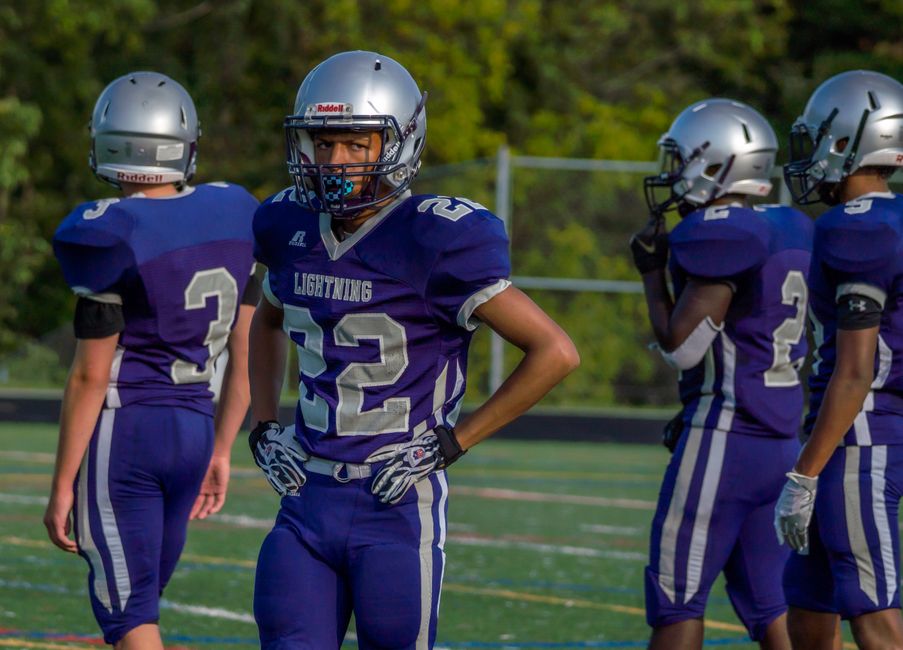 Young athletes in football uniforms ready for an outdoor game.