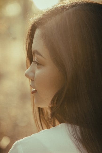 Close-up portrait of a young woman in soft golden light, looking peaceful.