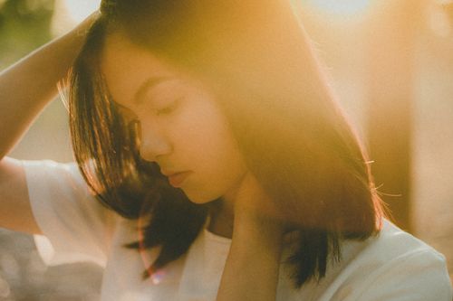 Free Serene portrait of a young woman in soft golden sunlight, evoking peace. Stock Photo