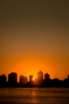 Silhouette of Balneário Camboriú skyline during a dramatic sunset over the ocean.