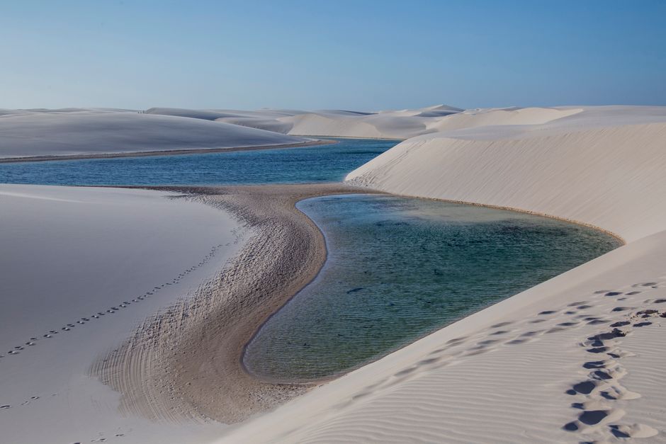 Aerial view of white sand dunes with turquoise blue lagoons beneath