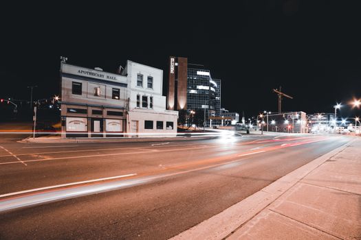 Dynamic city night scene with vibrant light trails and illuminated buildings.