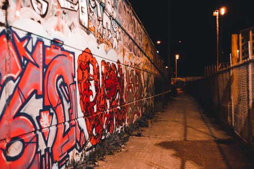Free Colorful graffiti on a dimly lit urban pathway at night, showcasing street art. Stock Photo