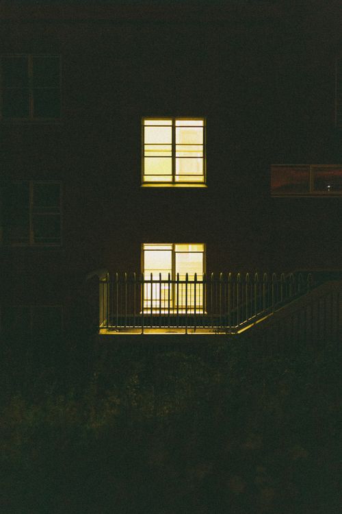 Free A building with glowing windows visible during a dim evening setting. Stock Photo