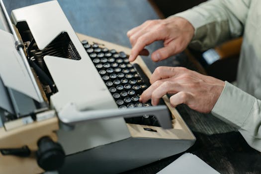 Close-up of hands typing on a vintage typewriter indoors.