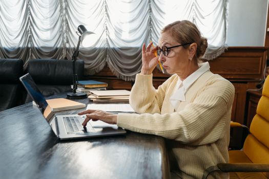 mature adult Japanese office worker studying laptop government subsidy