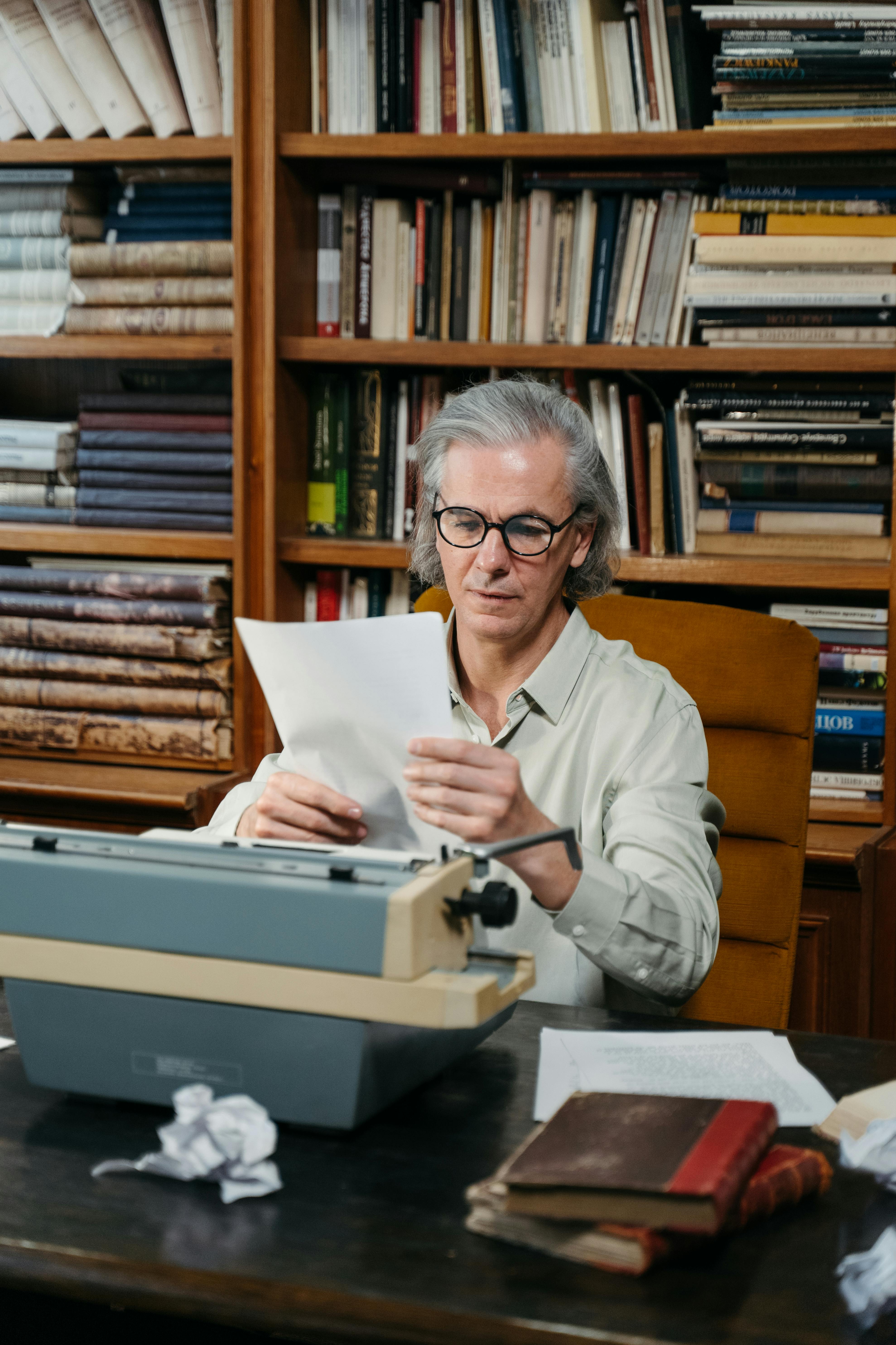 A Man in Blue Shirt Sitting on a Gray Padded Chair in the Library ...