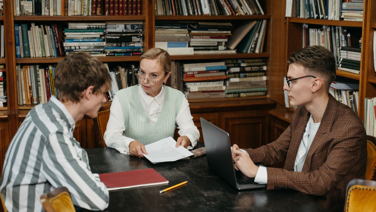 Grupo de adultos conversando alrededor de una mesa en una biblioteca