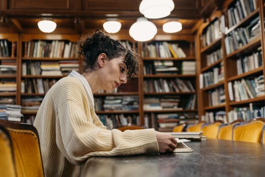 Adult student studying in a classic library, focused on learning and reading.