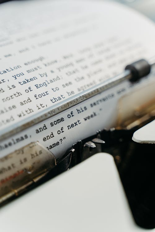 Close Up Shot of a Typewriter with White Paper