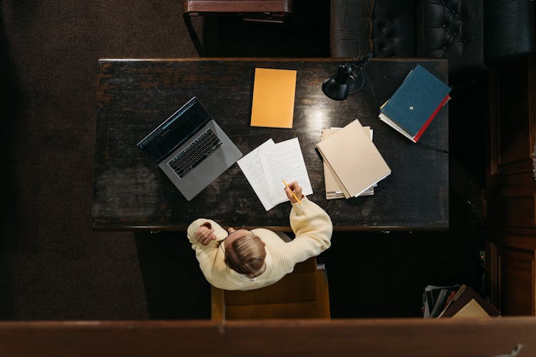 Top View Of A Person Sitting Behind A Desk