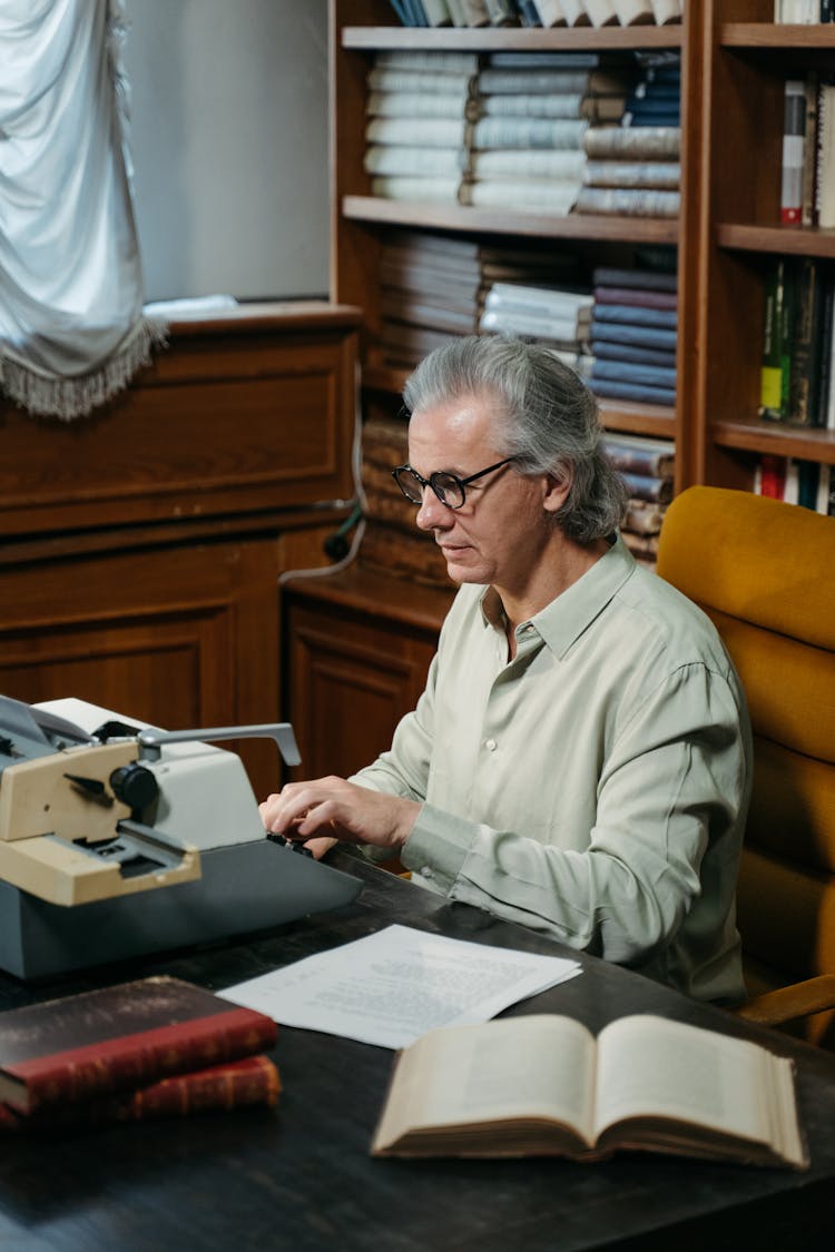 A Man Typing On A Vintage Typewriter