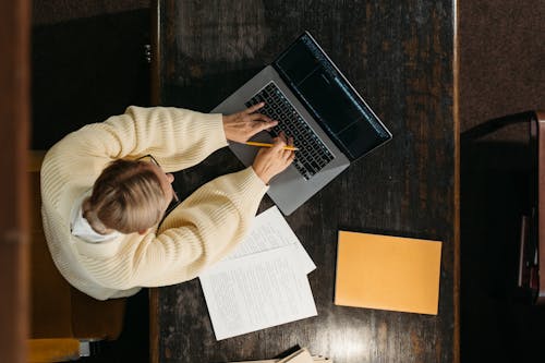 Free High-Angle Shot of a Person Using a Laptop Stock Photo
