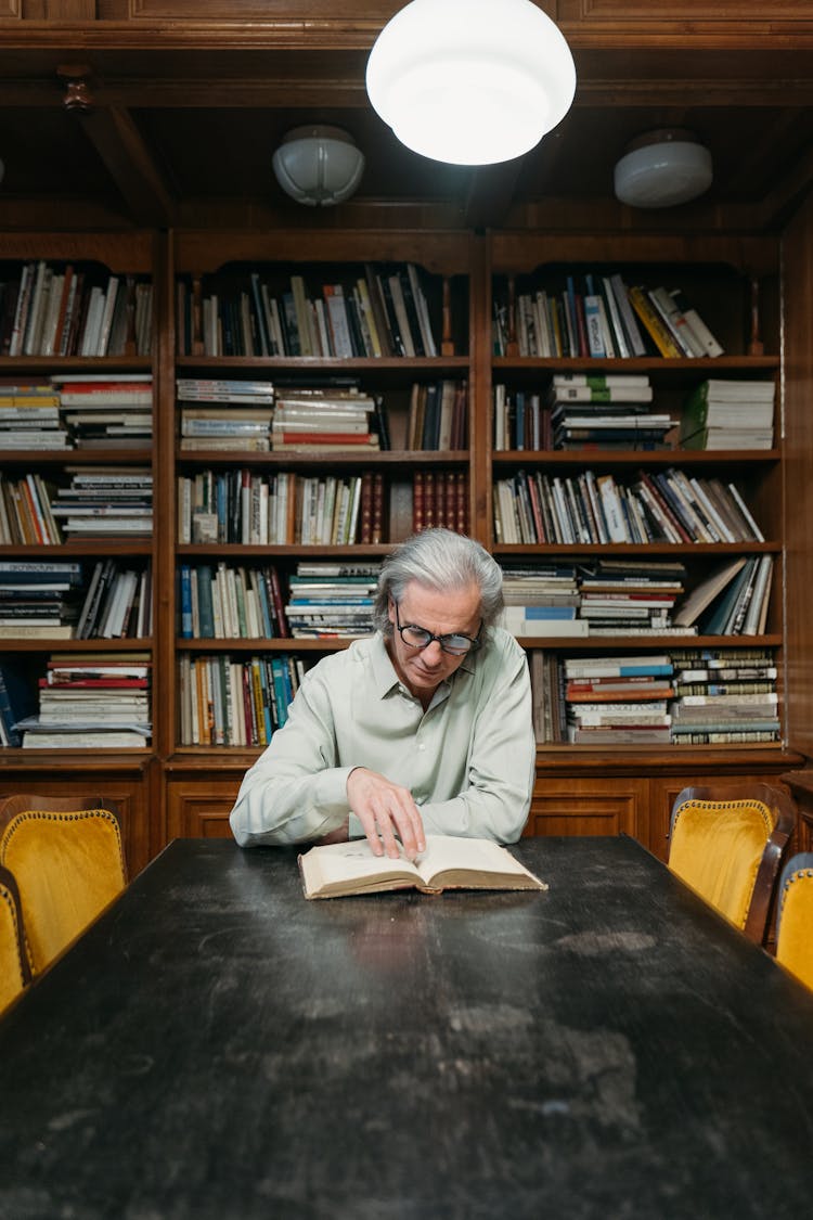 Man In White Long Sleeves Shirt Reading A Book