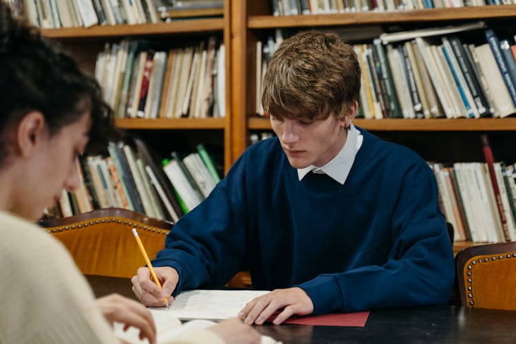 A Man And A Woman Studying In The Library