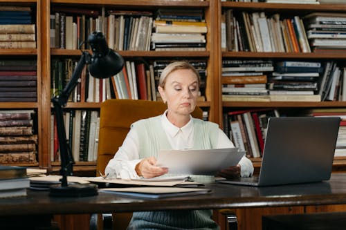 A Woman Looking at Documents while Sitting on a Chair