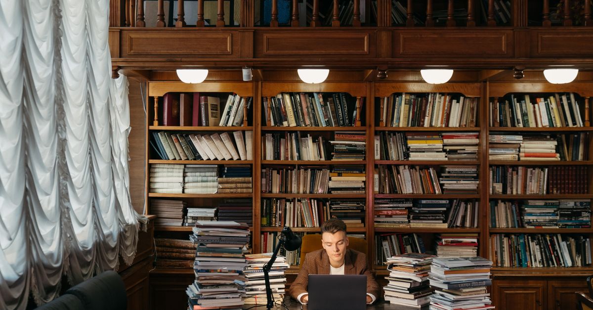 NTC Ho student studying in library with laptop and science textbooks